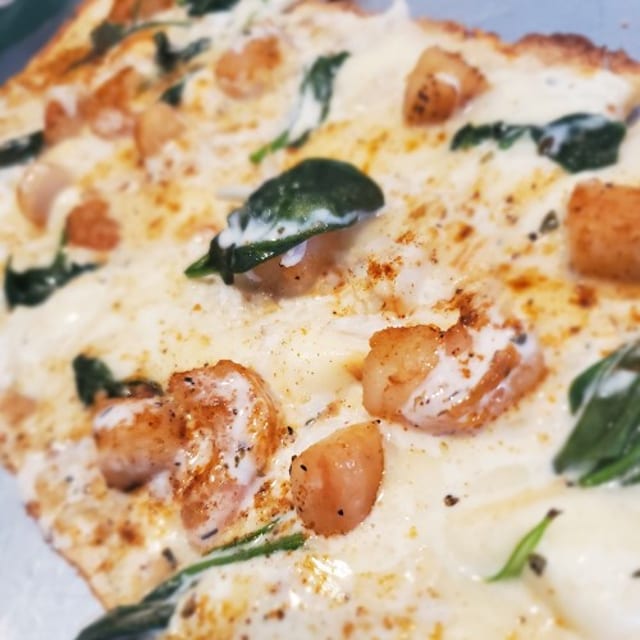 BLACKENED SEAFOOD ALFREDO PIZZA.